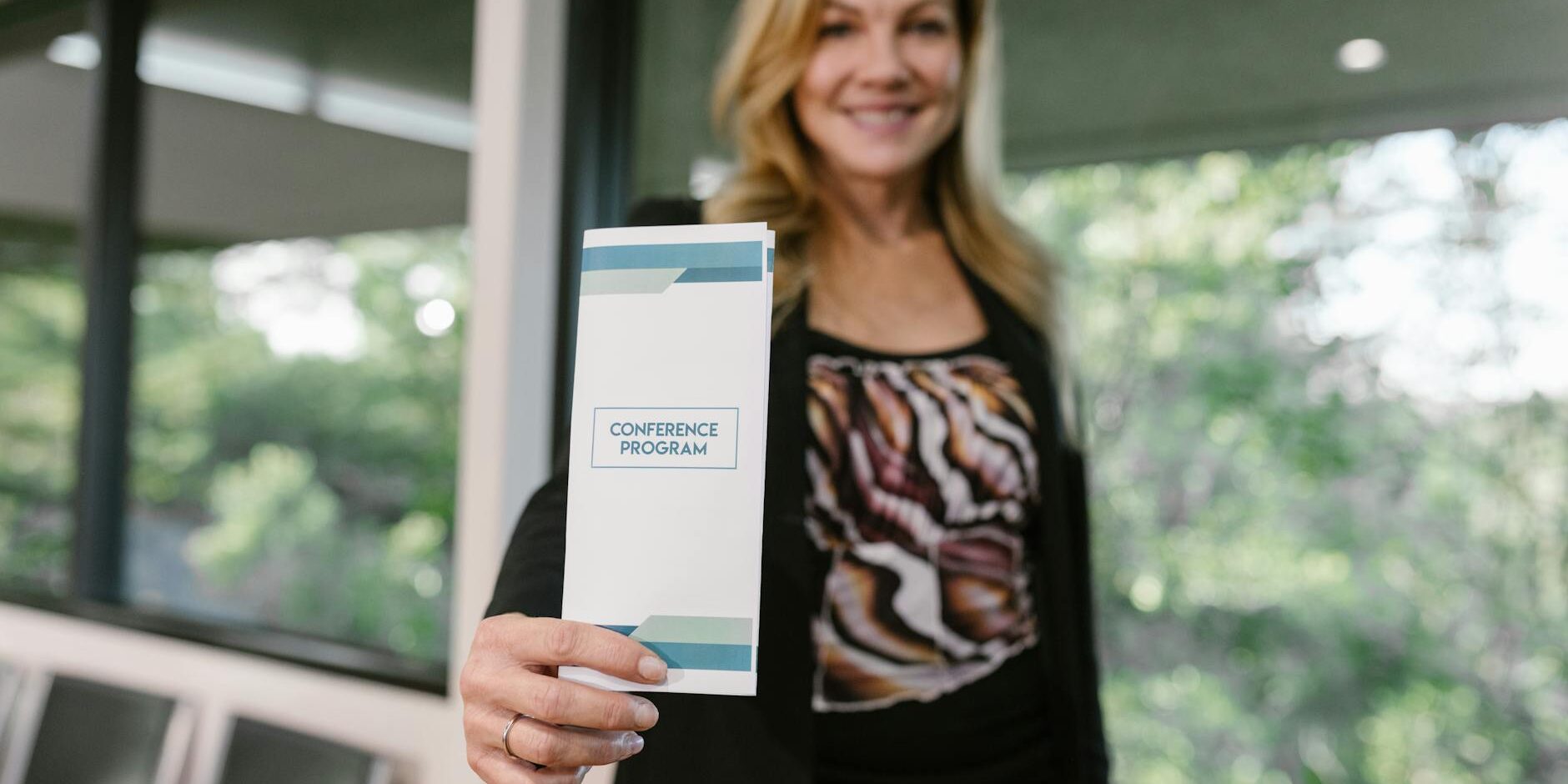 1742125343165×153349628191860260-feature woman holding a Cadti printed business flyer for conference -Catdi Houston printing solutions