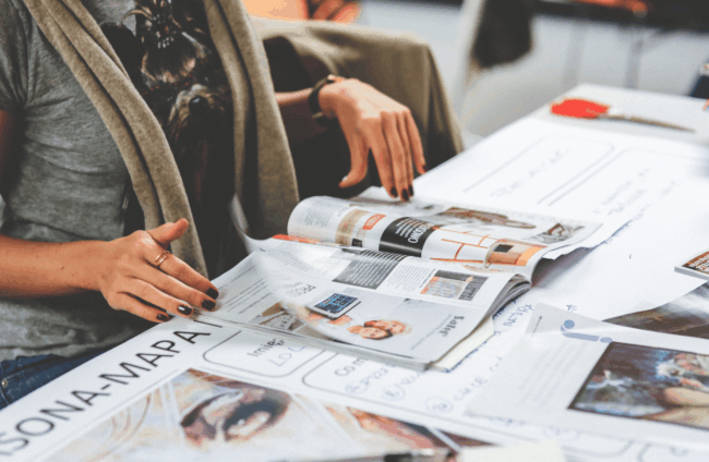 woman reviewing printing collateral on table at Houston central office - Catdi Houston printing packages