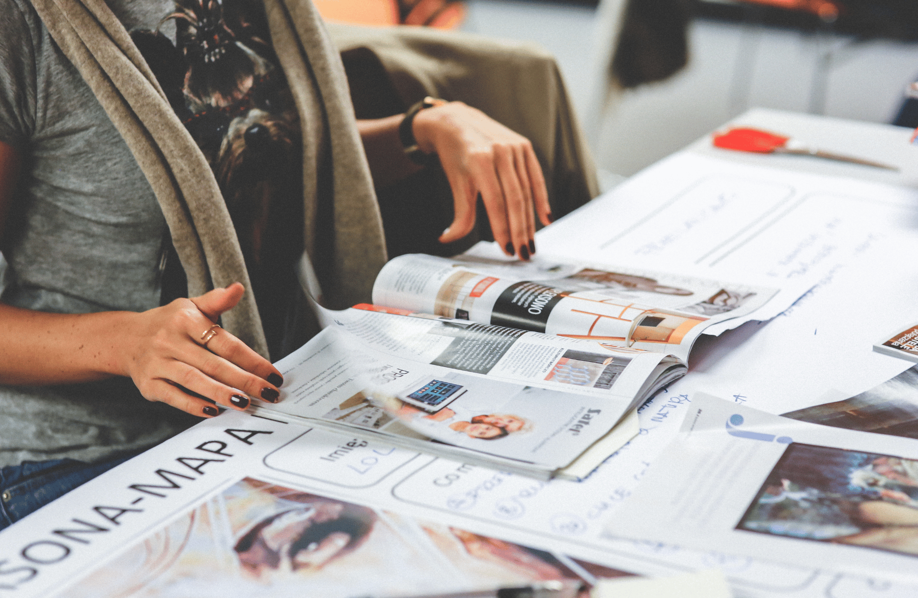 woman reviewing printing collateral on table at Houston central office - Catdi Houston printing packages